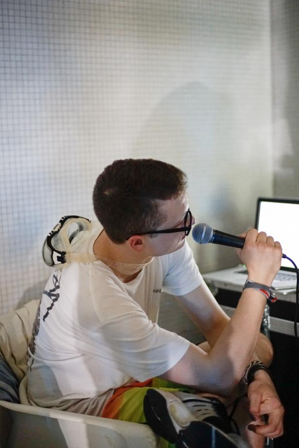 Julian Schmiederer spricht in ein Mikrofon vor einem Laptop.