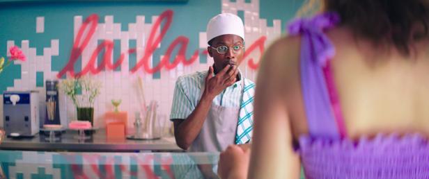 Ein Mann mit Kochmütze steht hinter der Theke eines Cafés.