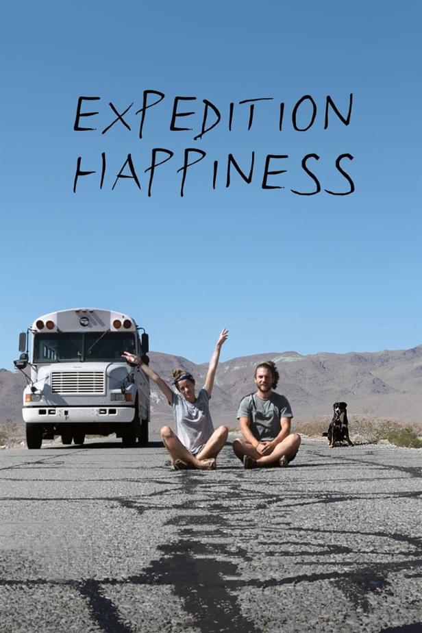 Ein Paar sitzt mit einem Hund und einem Bus auf einer Straße vor einer Bergkulisse; darüber steht „Expedition Happiness“.