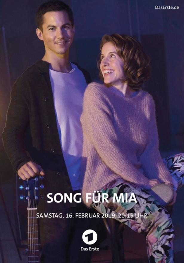 Ein Mann mit Gitarre und eine Frau, vermutlich aus dem Film „Song für Mia“.