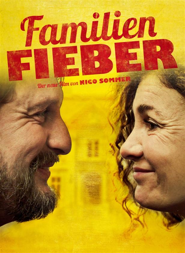 Das Filmplakat für „Familienfieber“ zeigt die Gesichter eines Mannes und einer Frau vor einem gelben Hintergrund.