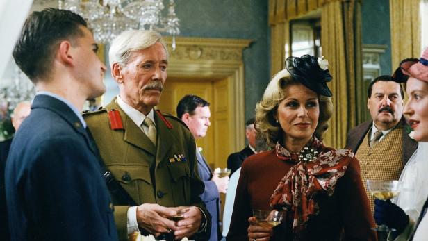 Eine Gesellschaft von Menschen, darunter ein Mann in Militäruniform, bei einer Veranstaltung.