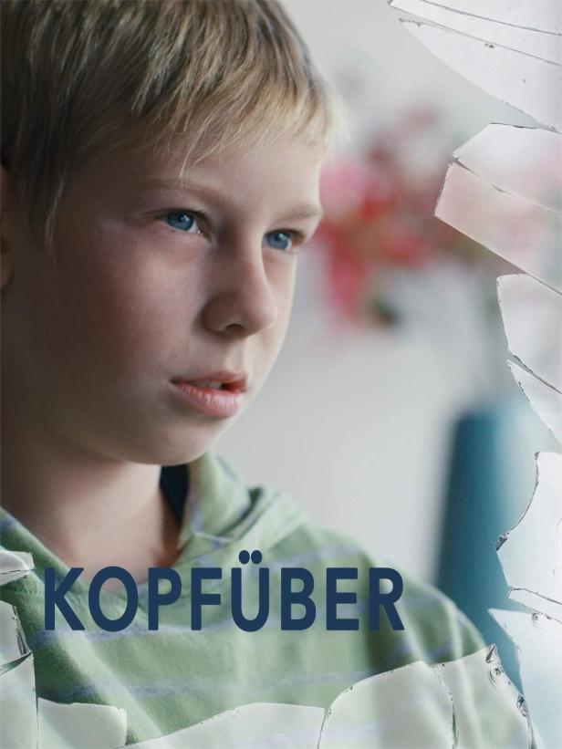 Ein blonder Junge mit blauen Augen schaut nachdenklich zur Seite; Glasscherben im Vordergrund.