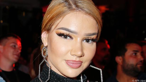 Shirin David mit opulenten Strassohrringen und einer blonden Dutt-Frisur bei einem öffentlichen Auftritt