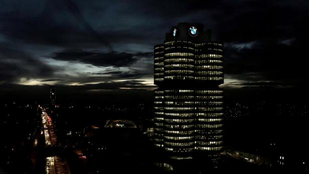 Das BMW-Hochhaus in München bei Nacht, beleuchtet mit dem BMW-Logo auf dem Dach.