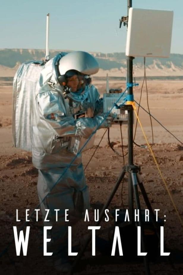 Ein Astronaut in einem Raumanzug arbeitet an einer Antenne in einer Wüstenlandschaft.