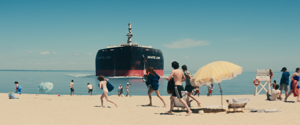 Ein Öltanker fährt auf einen Strand voller Menschen zu