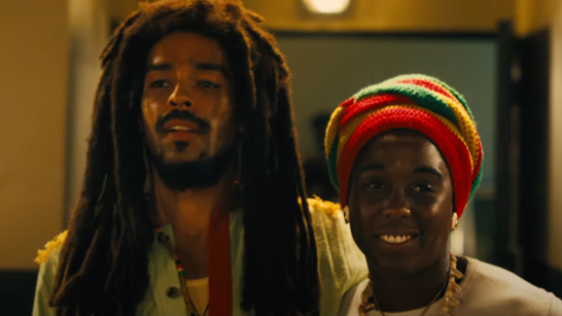 Bob Marley mit Rastalocken steht neben seiner Schwarzen Frau mit einem bunten Turban