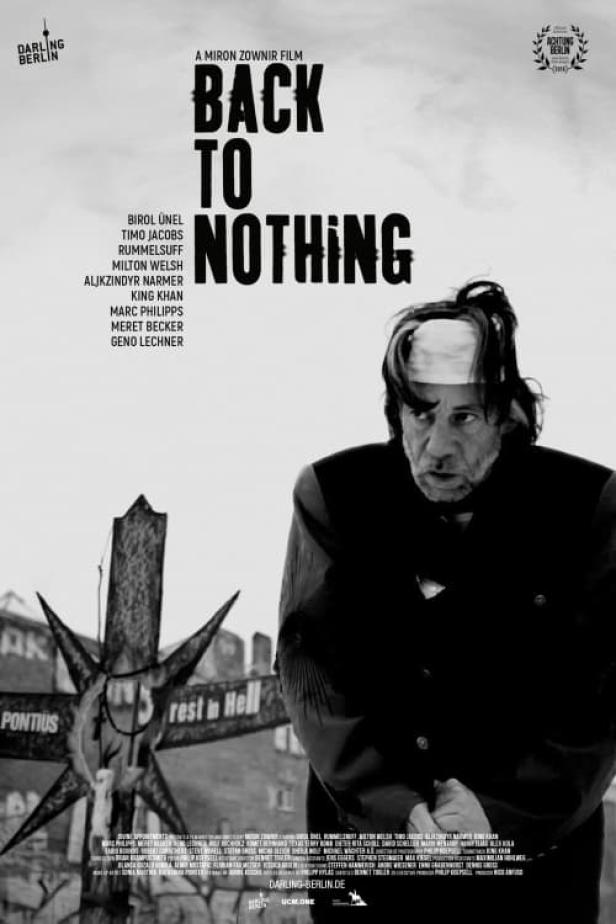 Schwarzweiß-Filmplakat für „Back to Nothing“ mit Birol Ünel und einem Kreuz mit der Aufschrift „Rest in Hell“.