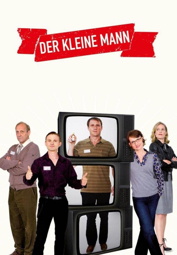 Das Filmplakat für „Der kleine Mann“ zeigt die Hauptdarsteller vor einem Stapel alter Fernseher.