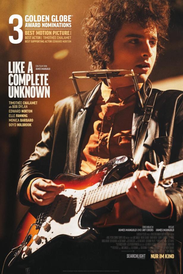 Timothée Chalamet als Bob Dylan mit Gitarre und Mundharmonika im Film „Like a Complete Unknown“.