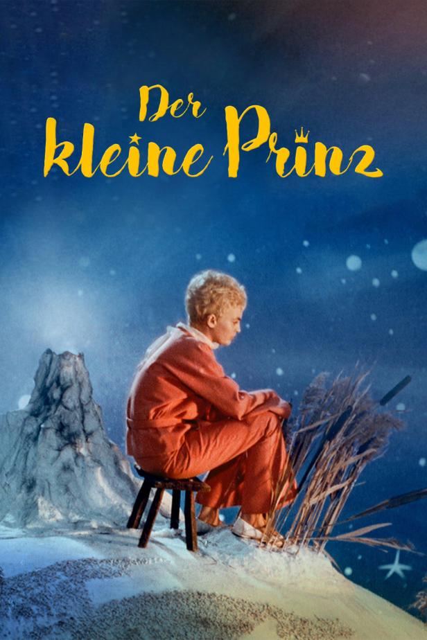 Ein junger Mann sitzt auf einem Hocker vor dem Hintergrund des Films „Der kleine Prinz“.