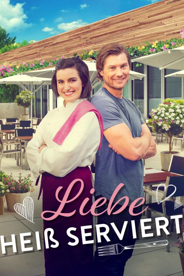 Ein Koch und ein Mann stehen vor einem Restaurant, im Vordergrund der Titel „Liebe heiß serviert“.