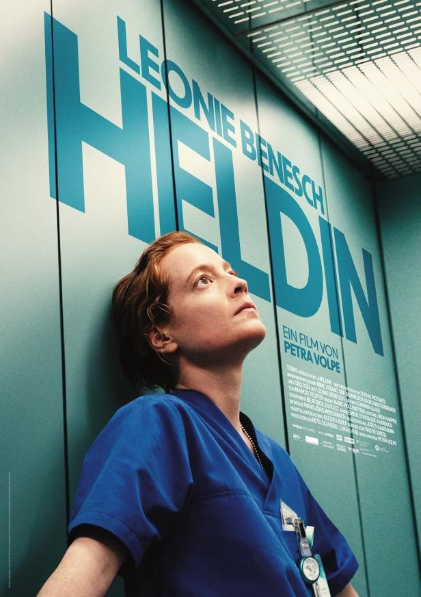 Das Filmplakat für „Heldin“ zeigt Leonie Benesch in blauer Arbeitskleidung vor einer blauen Wand.