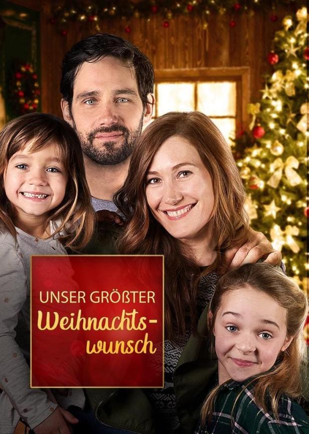 Das Filmplakat für „Unser größter Weihnachtswunsch“ zeigt eine glückliche Familie vor einem Weihnachtsbaum.