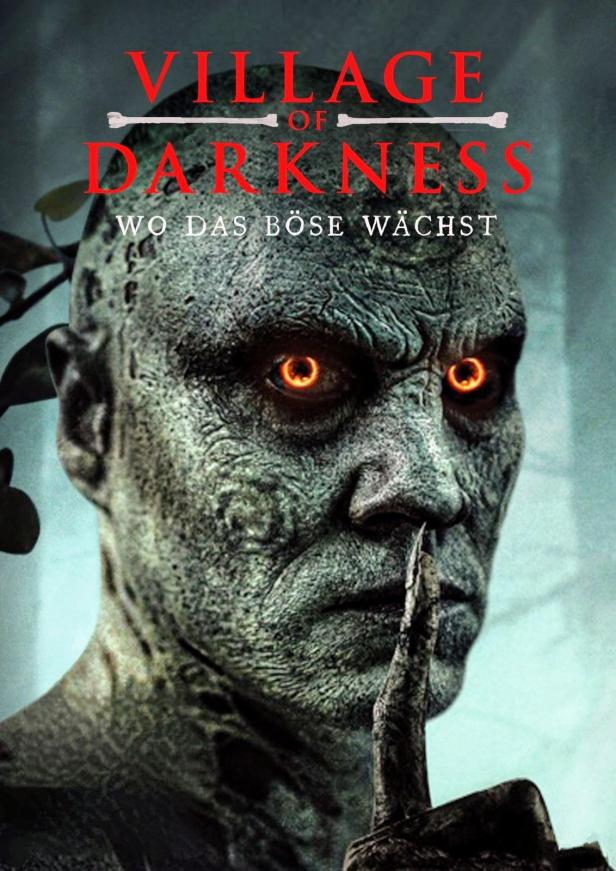 Das Filmplakat für „Village of Darkness“ zeigt ein unheimliches Gesicht mit leuchtenden Augen.