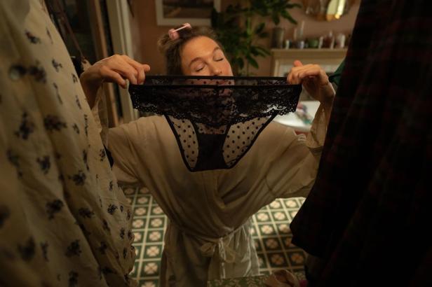 Bridget Jones hält eine schwarze Unterhose mit Spitze vor ihr Gesicht.