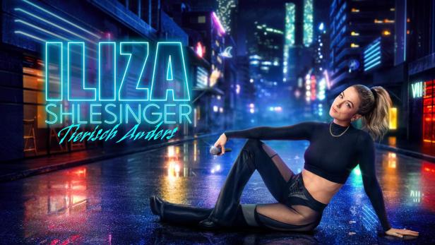 Iliza Shlesinger posiert vor einem neonbeleuchteten Stadthintergrund für „Tierisch Anders“.