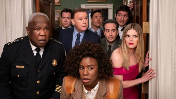 Eine Gruppe von Menschen blickt mit überraschten Gesichtern aus einem Raum.