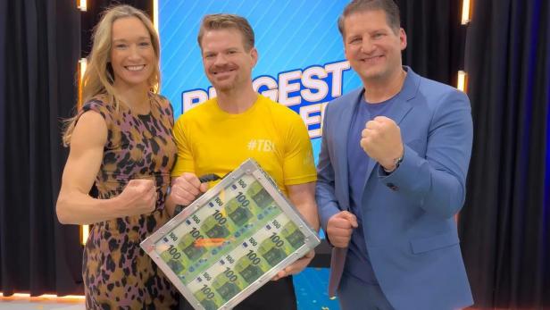 Drei Personen posieren mit einem Koffer voller 100-Euro-Scheine für „The Biggest Loser“.