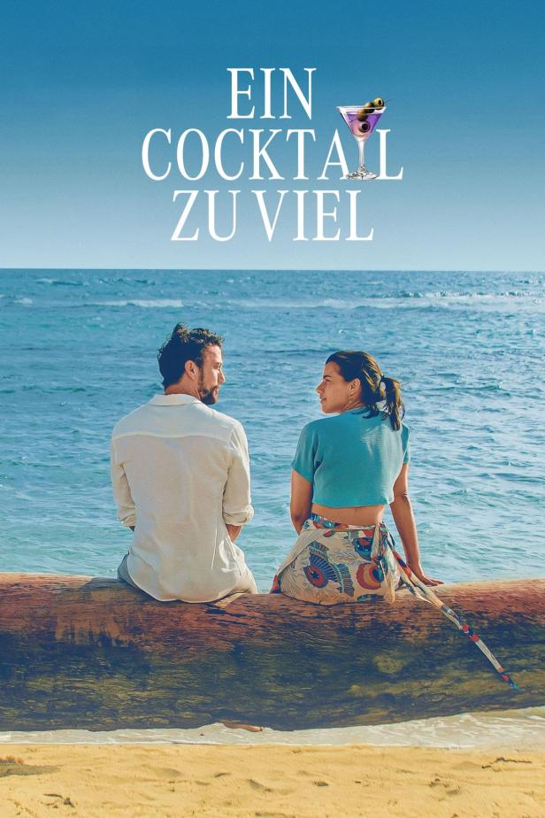 Ein Mann und eine Frau sitzen am Strand auf einem Baumstamm vor dem Meer.