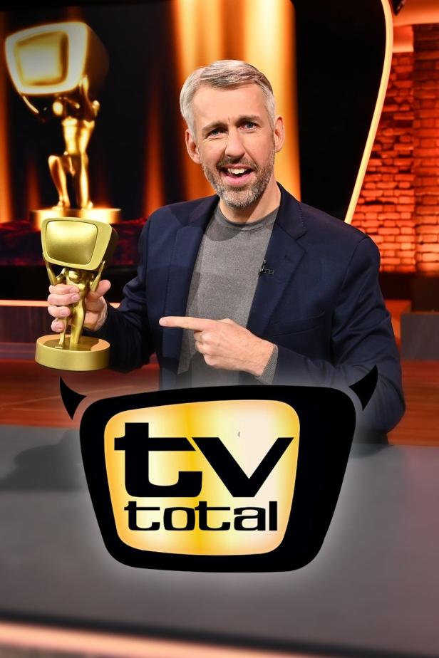 Ein Mann im Studio von „TV Total“ hält eine goldene Statue.