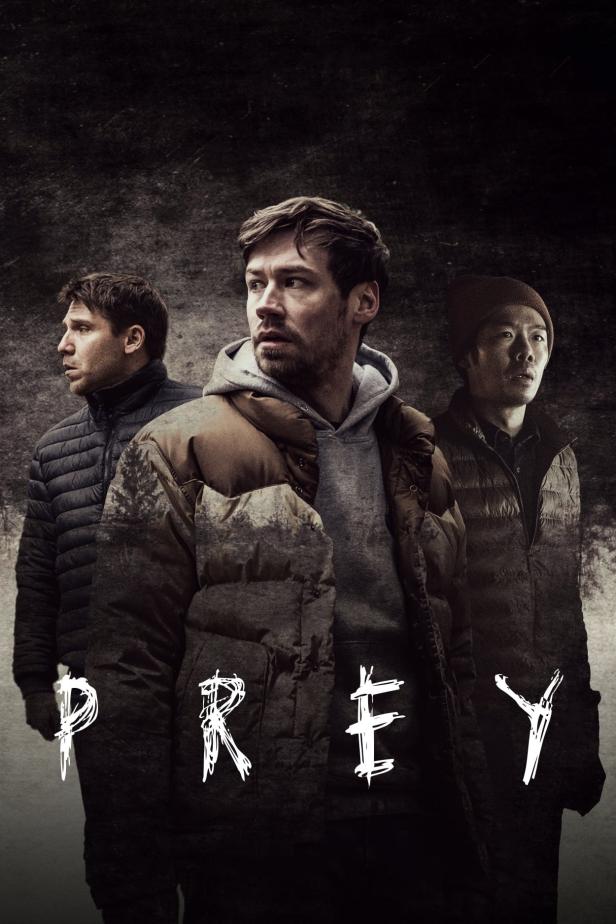 Das Filmplakat für „Prey“ zeigt drei Männer in Winterkleidung vor einem dunklen Hintergrund.