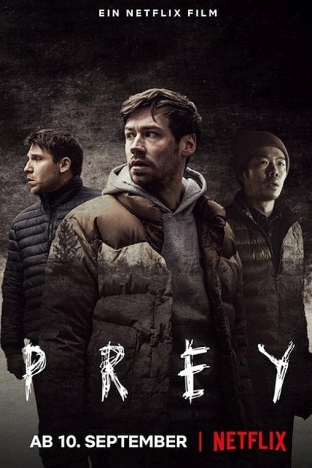 Das Filmplakat für „Prey“ zeigt drei junge Männer in winterlicher Umgebung.