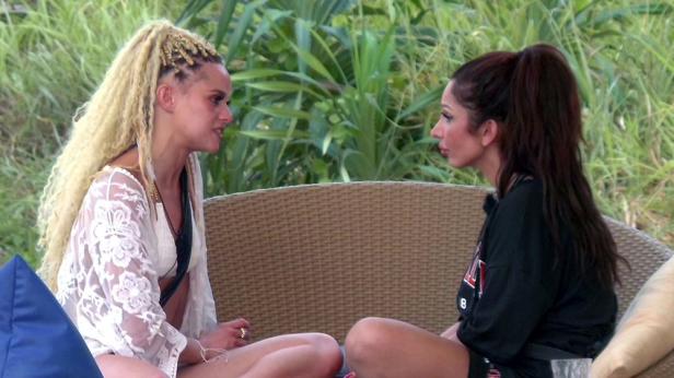 Zwei Frauen sitzen draußen und unterhalten sich.