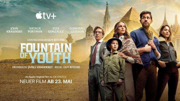 Das Filmplakat für „Fountain of Youth“ mit John Krasinski, Natalie Portman und anderen vor verschiedenen Wahrzeichen.