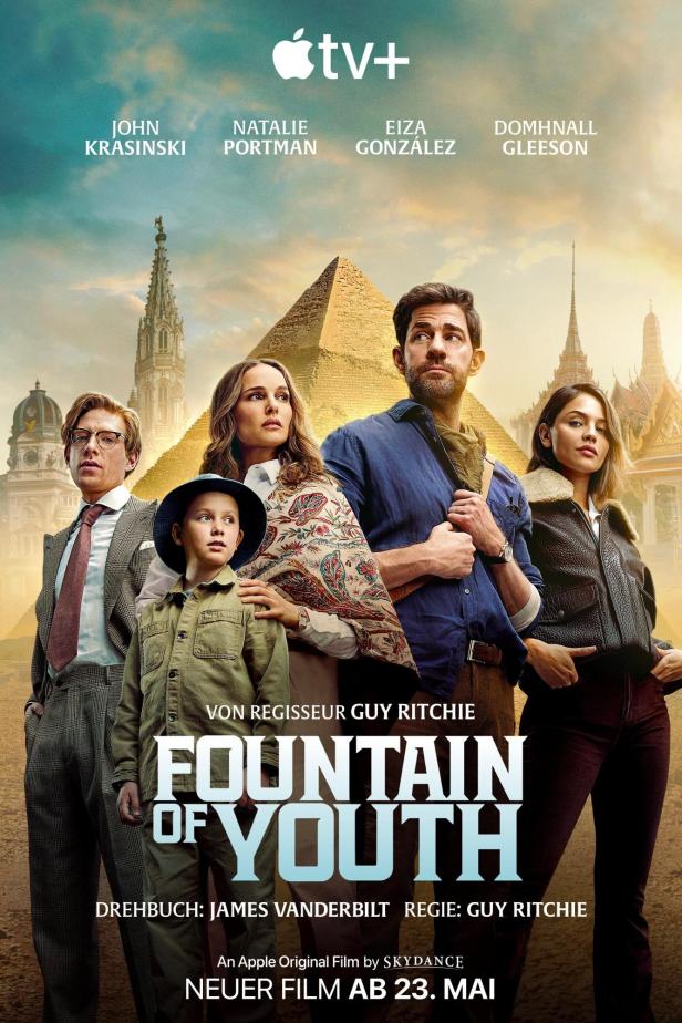 Das Filmplakat für „Fountain of Youth“ mit John Krasinski, Natalie Portman und anderen vor verschiedenen Weltwundern.