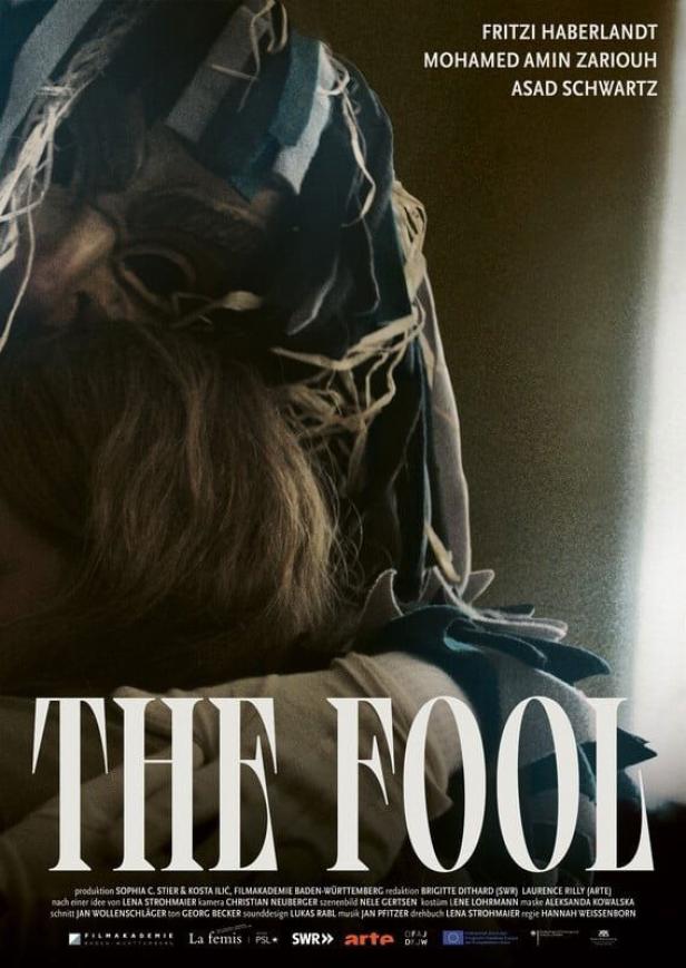 Das Filmplakat für „The Fool“ zeigt eine Person mit einer gestreiften Kopfbedeckung.