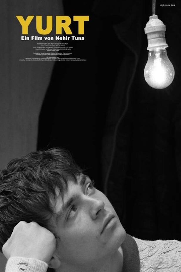 Ein junger Mann blickt auf eine Glühbirne; Filmposter für „Yurt“.