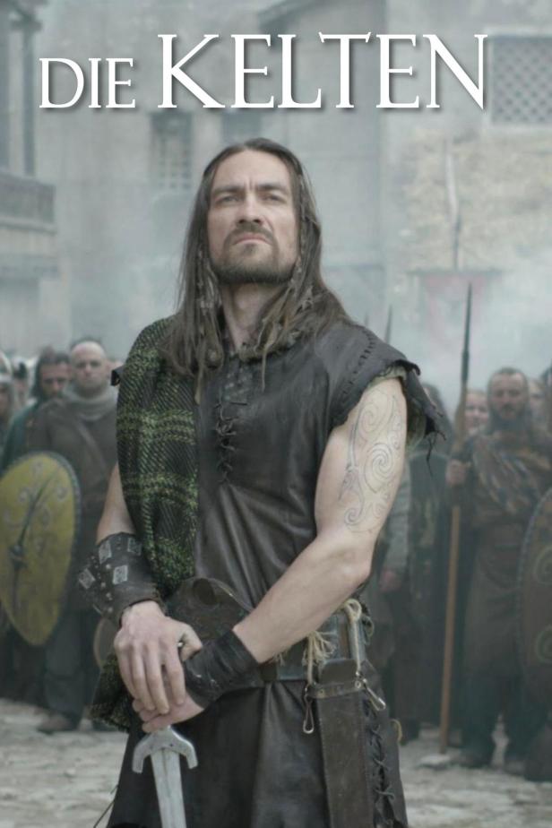 Ein Mann in keltischer Kleidung steht vor einer Gruppe von Kriegern.