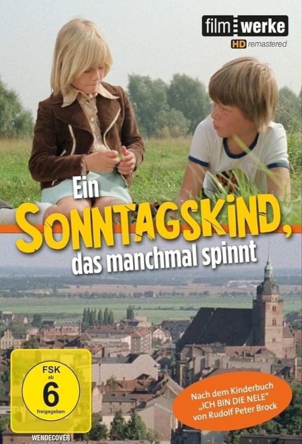 Das Cover des Films „Ein Sonntagskind, das manchmal spinnt“ zeigt zwei Kinder vor einer Stadtansicht.