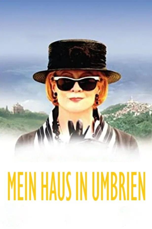 Das Filmplakat für „Mein Haus in Umbrien“ zeigt eine Frau mit Hut und Sonnenbrille vor einer italienischen Landschaft.