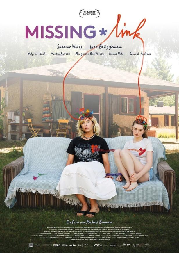 Das Filmplakat für „Missing Link“ zeigt Susanne Wolff und Luca Brüggemann auf einem Sofa vor einem Haus.