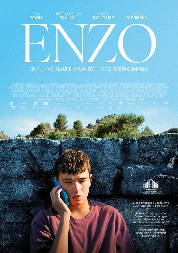 Ein junger Mann telefoniert vor dem Hintergrund des Filmplakats „Enzo“.