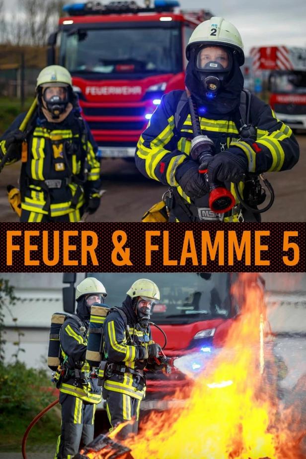 Feuerwehrleute in Schutzkleidung löschen ein Feuer vor einem roten Feuerwehrauto.