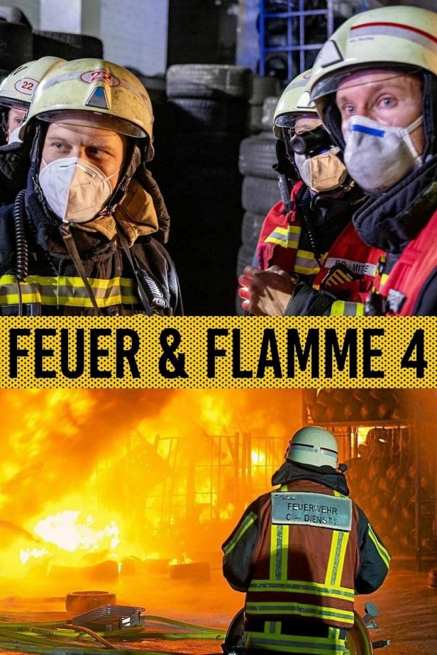 Feuerwehrleute stehen vor einem brennenden Gebäude.