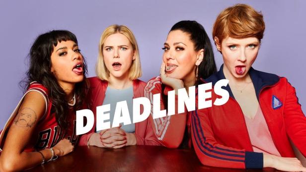 Vier Frauen sitzen an einem Tisch und strecken ihre Zungen heraus; im Vordergrund steht das Wort „Deadlines“.