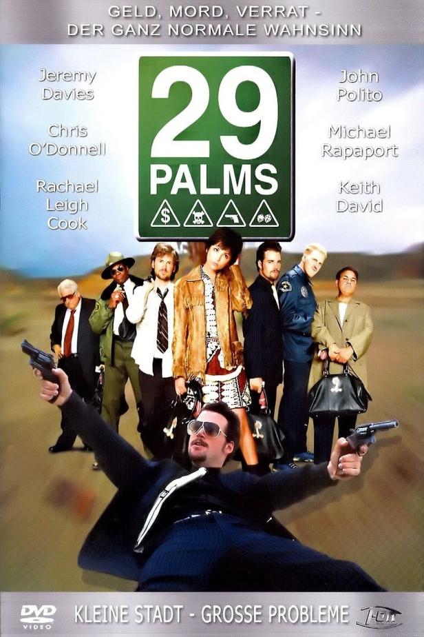 Das Filmplakat für „29 Palms“ zeigt eine Gruppe von bewaffneten Personen in einer Wüstenlandschaft.