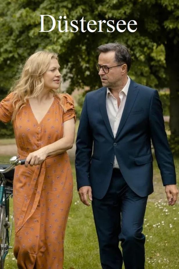 Ein Mann im Anzug und eine Frau mit einem Fahrrad, vermutlich eine Szene aus „Düstersee“.