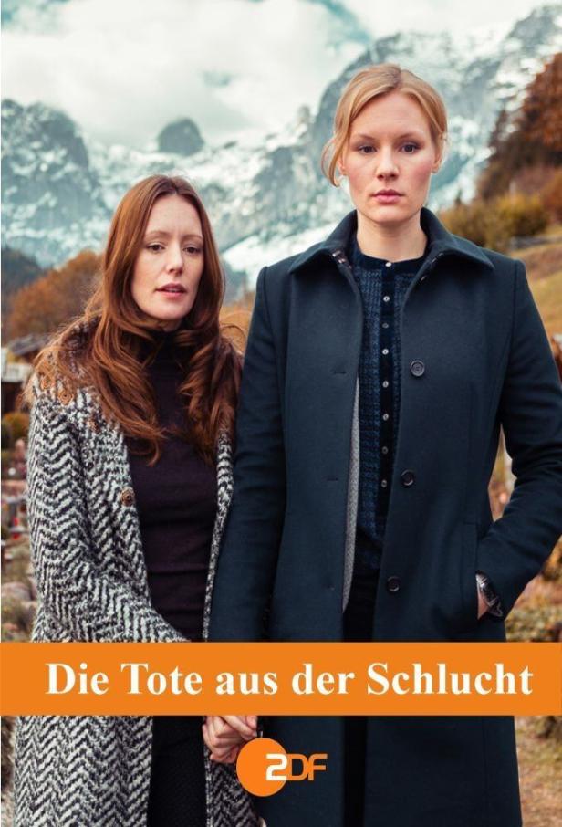 Zwei Frauen stehen vor einer Bergkulisse, möglicherweise eine Szene aus „Die Tote aus der Schlucht“.