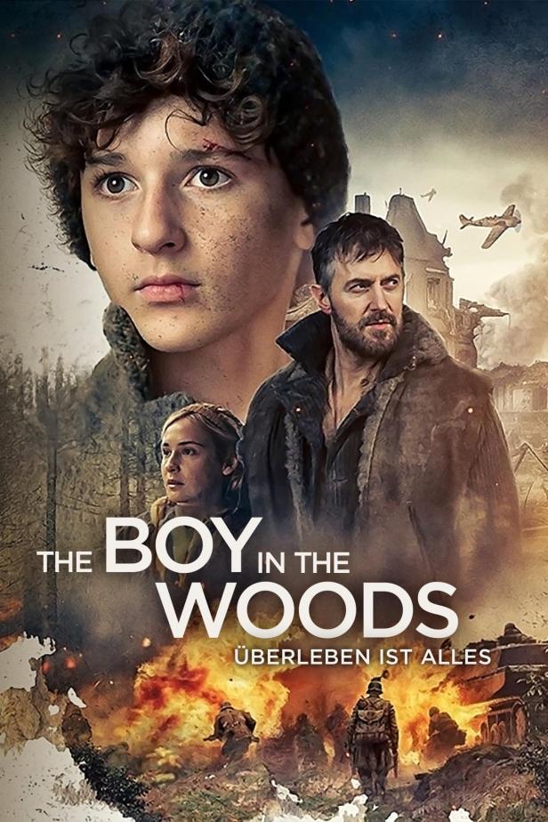 Das Filmplakat für „The Boy in the Woods“ zeigt einen Jungen, einen Mann und eine Frau vor einer zerstörten Landschaft.