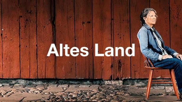 Eine Frau sitzt vor einer roten Holzwand; im Vordergrund der Titel „Altes Land“.