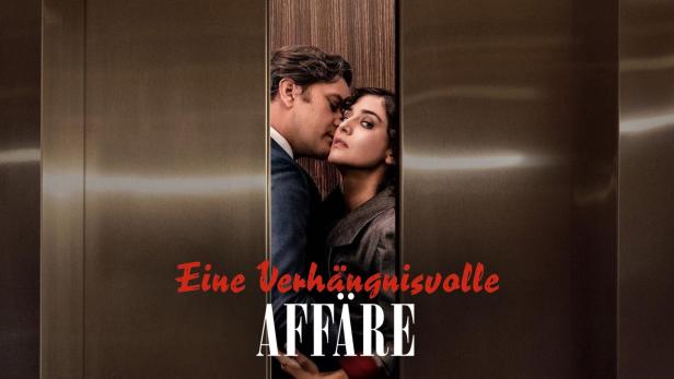 Ein Mann flüstert einer Frau im Aufzug ins Ohr.