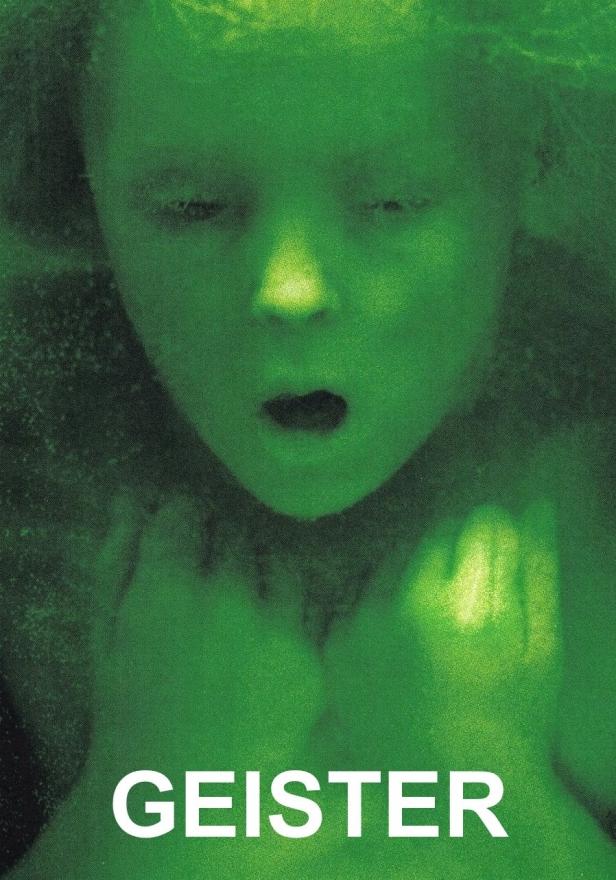 Das grünliche Gesicht eines Kindes mit dem Titel „Geister“ im Vordergrund.