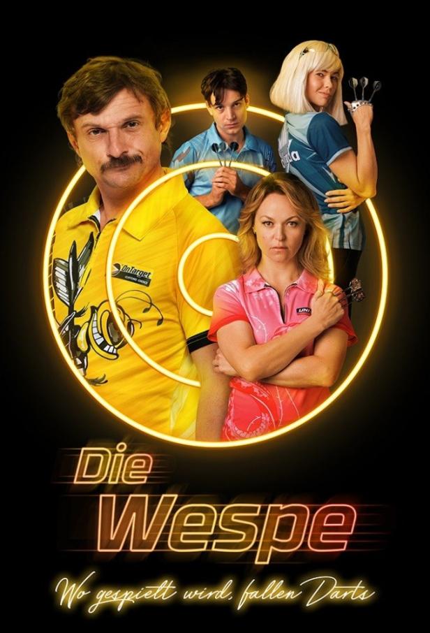 Das Filmplakat für „Die Wespe“ zeigt vier Dartspieler vor einem gelben Kreis.