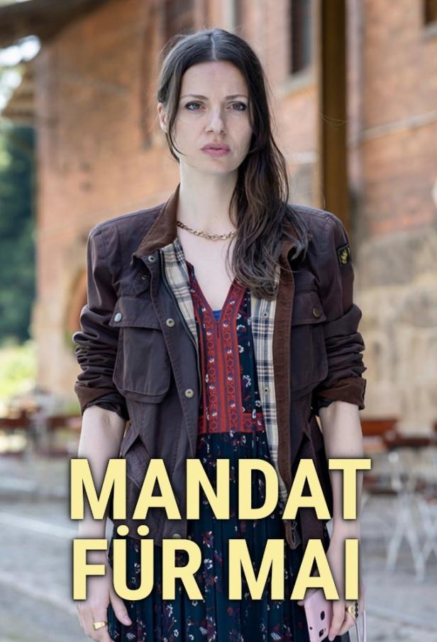 Eine Frau in Jacke und Kleid, möglicherweise ein Filmplakat für „Mandat für Mai“.